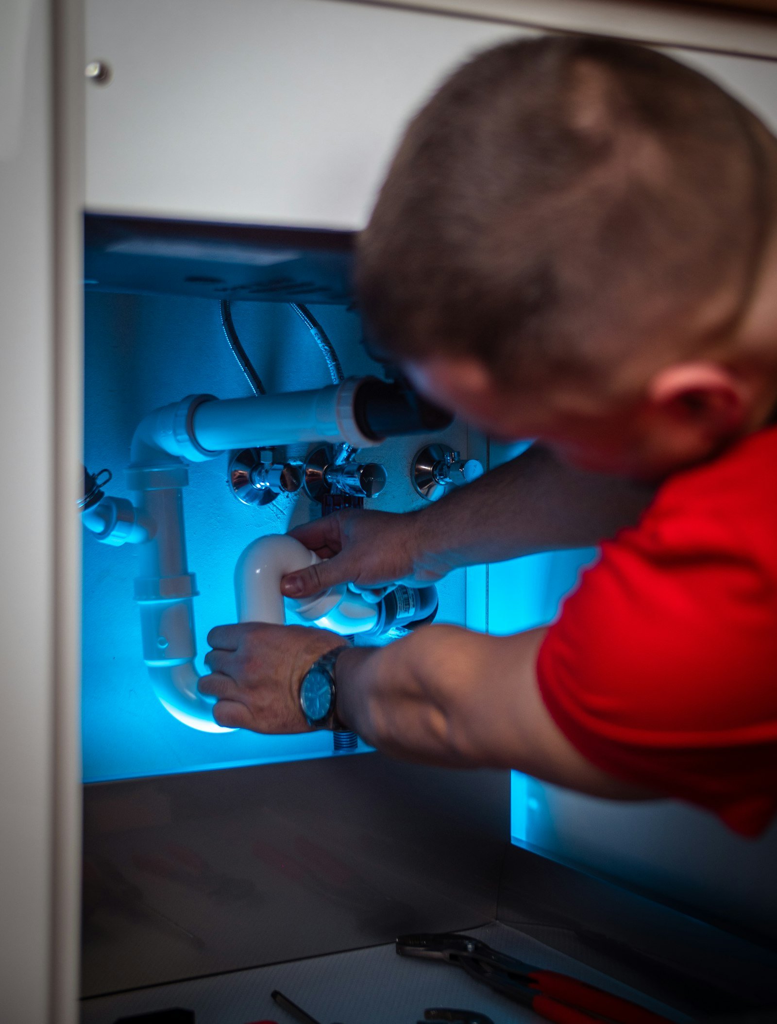 Technician working beneath a kitchen sink