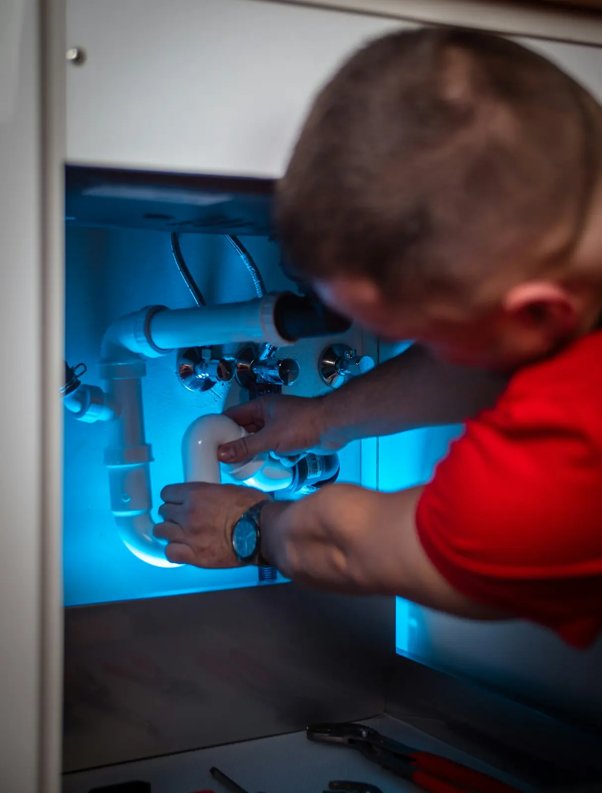 Technician working beneath a kitchen sink